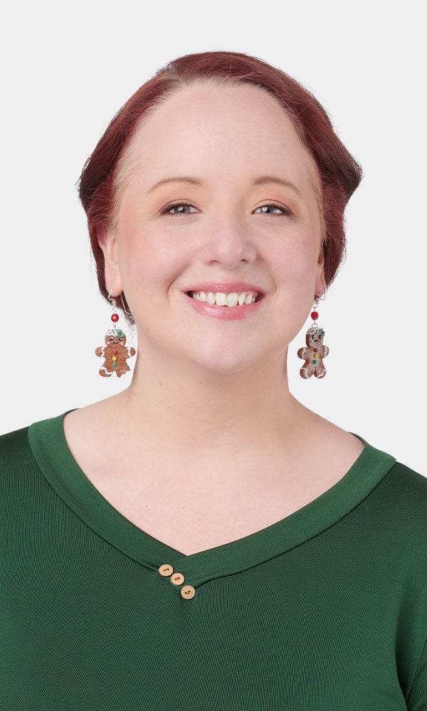 Model wearing gingerbread men earrings made with polymer clay